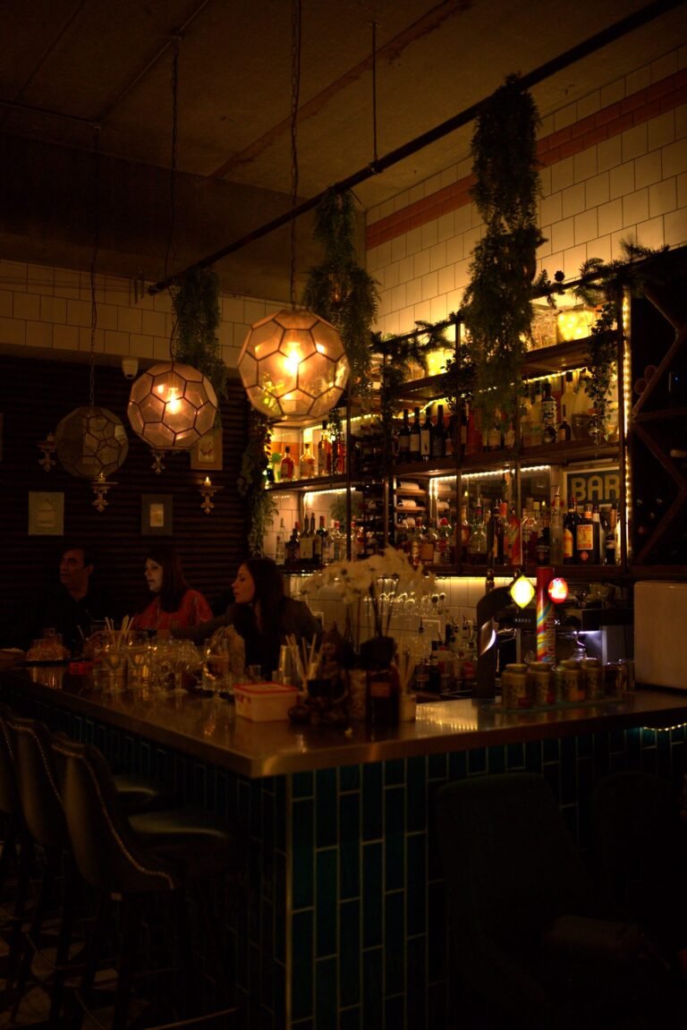 The bar at Chit Chaat at night, lit by warm pendant lights
