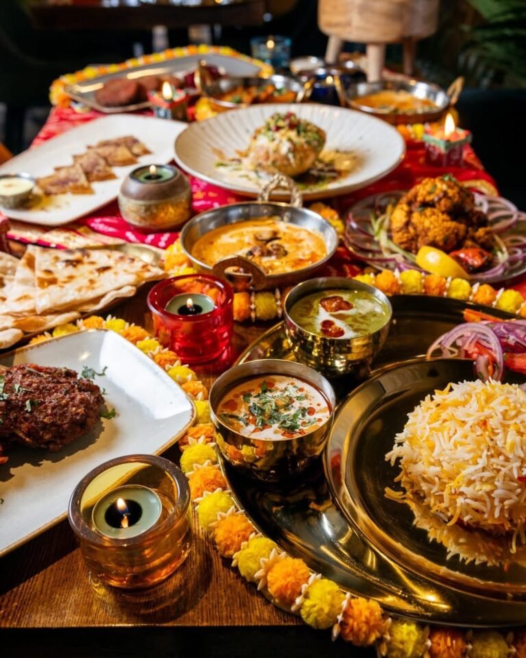 A Diwali table spread at Chit Chaat with biryani, curries, naan, kebabs, marigolds and candles