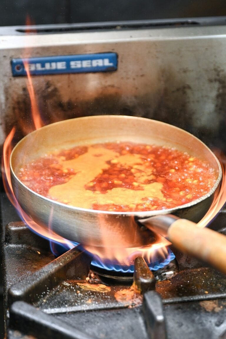 A pan of sauce over a high flame in the Chit Chaat kitchen