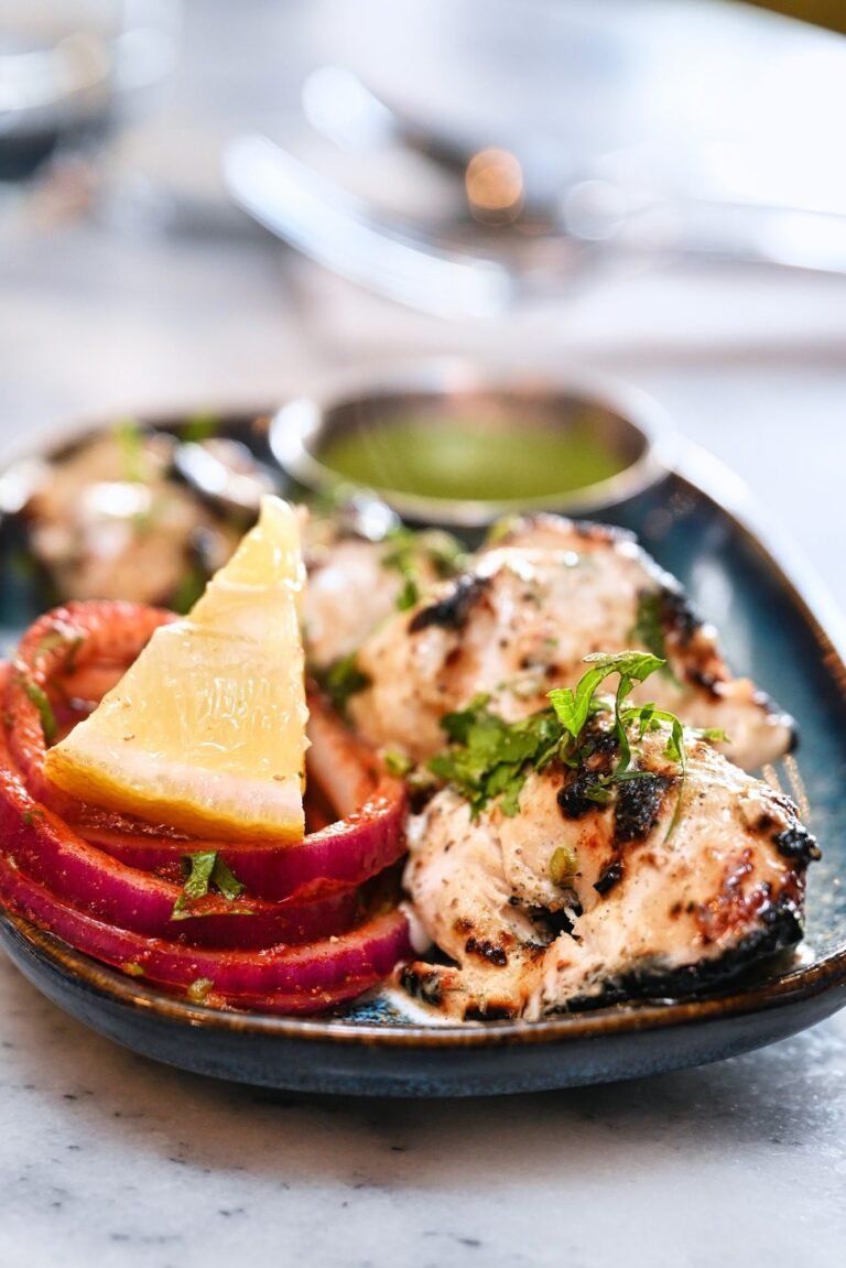 Malai chicken tikka served with lemon, onion and green chutney
